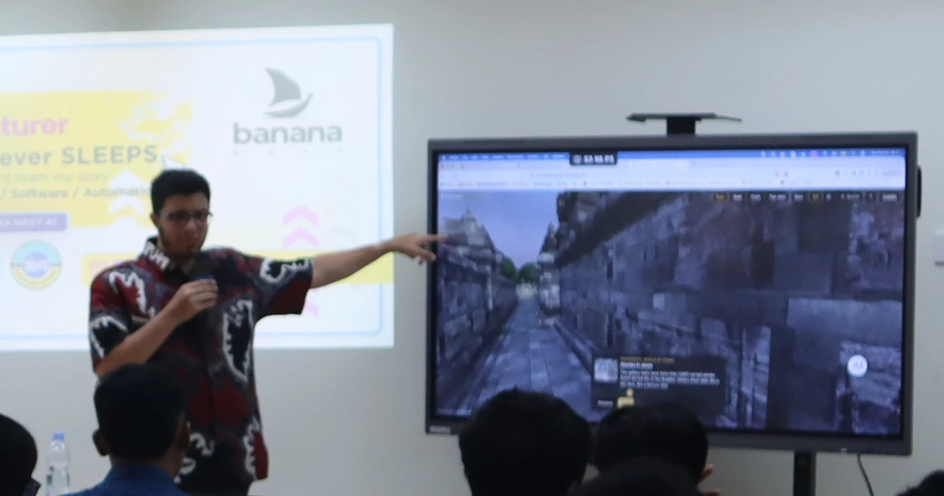 Omer Kara points at a large screen showing the 3D Borobudur demo website during his lecture